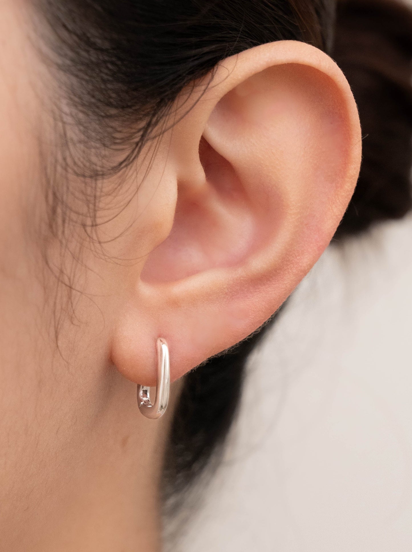 Mini huggie chunky earrings shown worn in the ear, highlighting its stylish look.