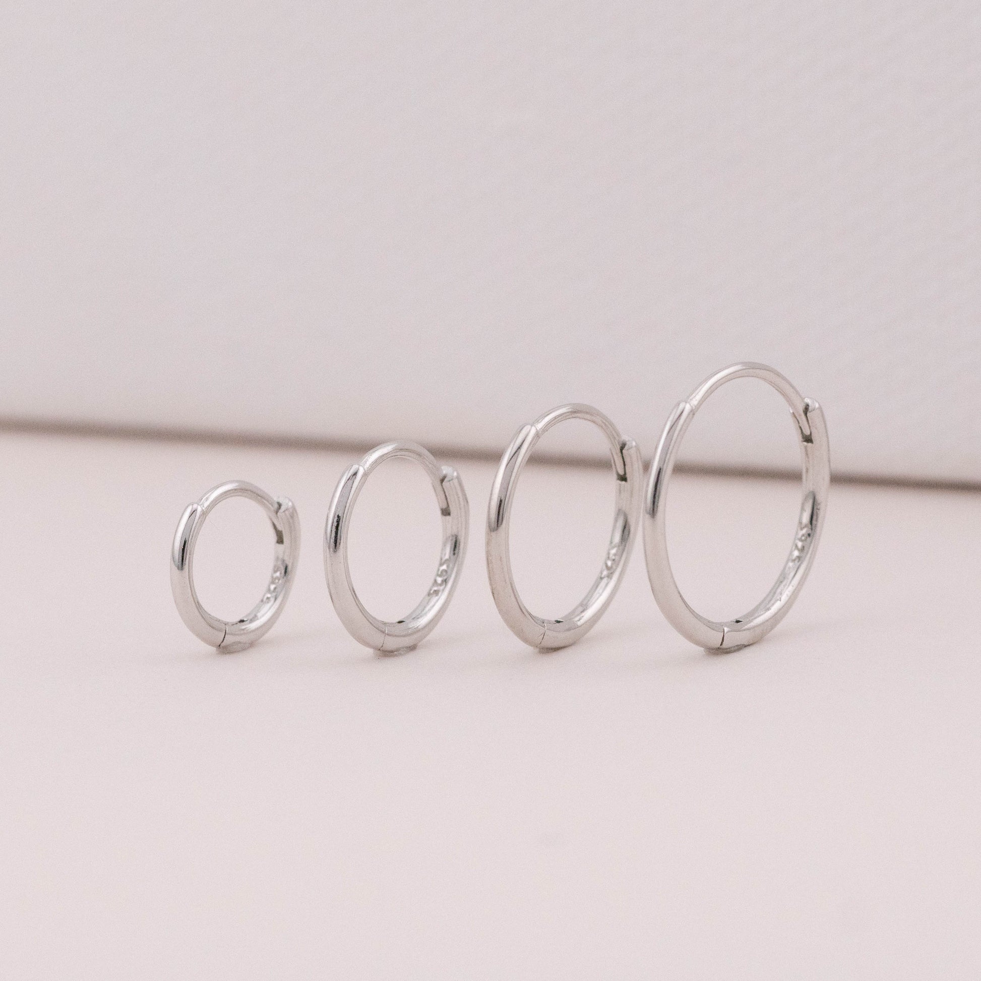 Sterling silver mini huggies side by side showing size differences, great for 3 holes and piercings.