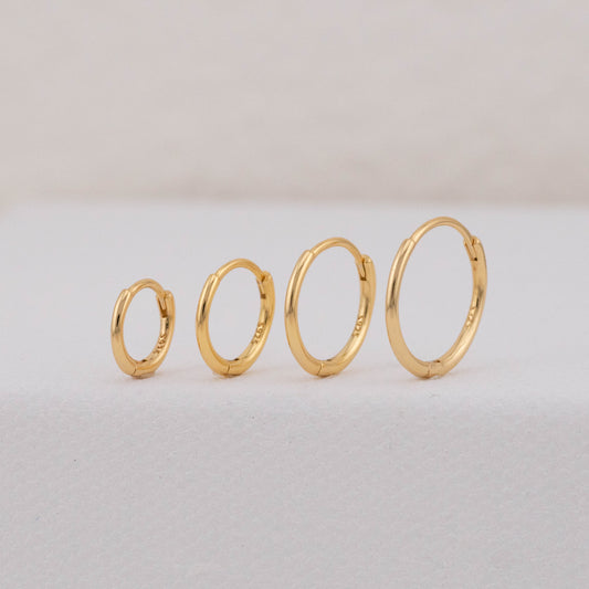 gold hoops in different sizes are displayed upright, showing stackable earring sets for 2 holes