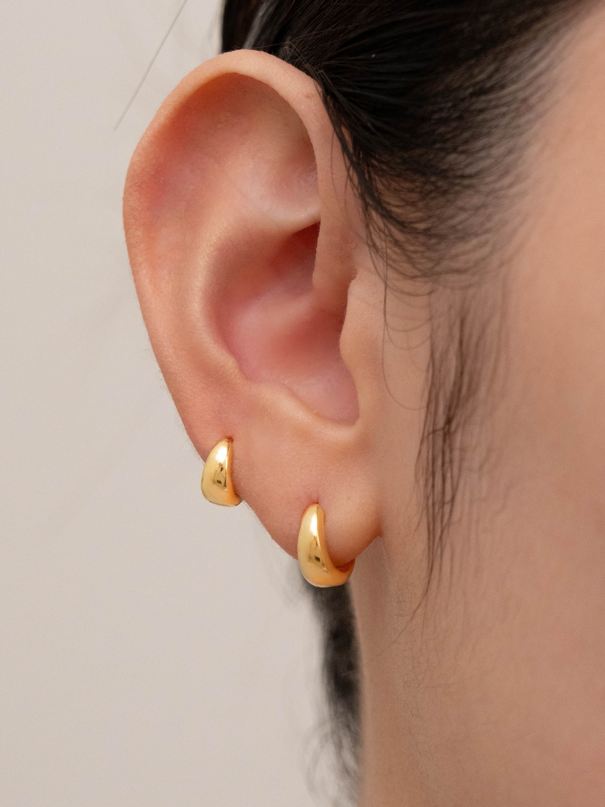 Earring sets for 2 holes shown worn in one ear, displaying how they look when paired together.