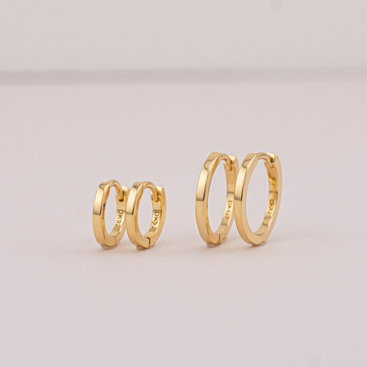 Gold mini huggies for 2 holes, 2 pairs placed on stage to show they can be worn as stack sets