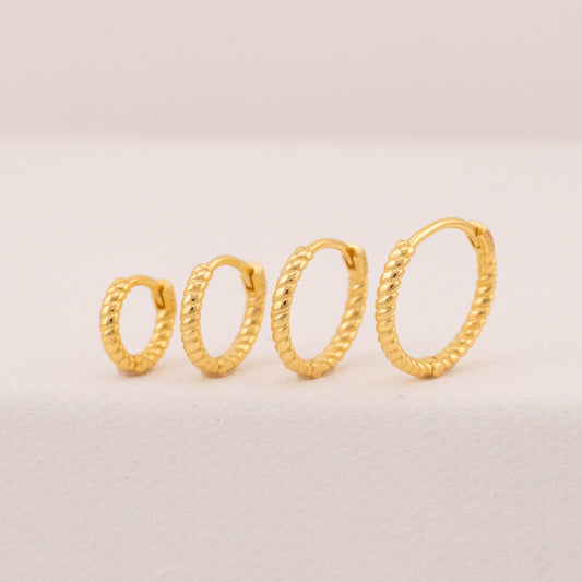 Mini huggie hoop earrings on stand, angled view showing croissant texture, suitable for 2 holes. 