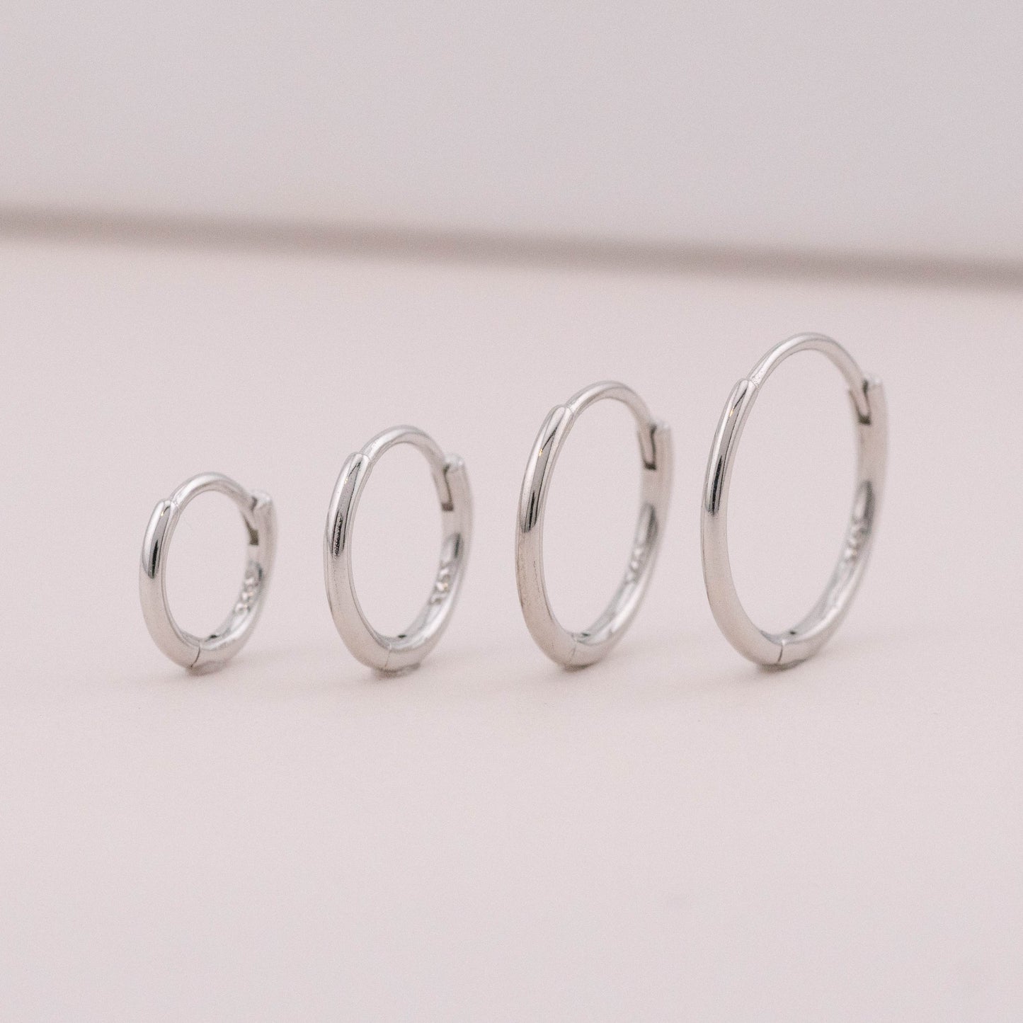 mini hoop earrings in different sizes are standing upright, showing it could be worn as stack sets