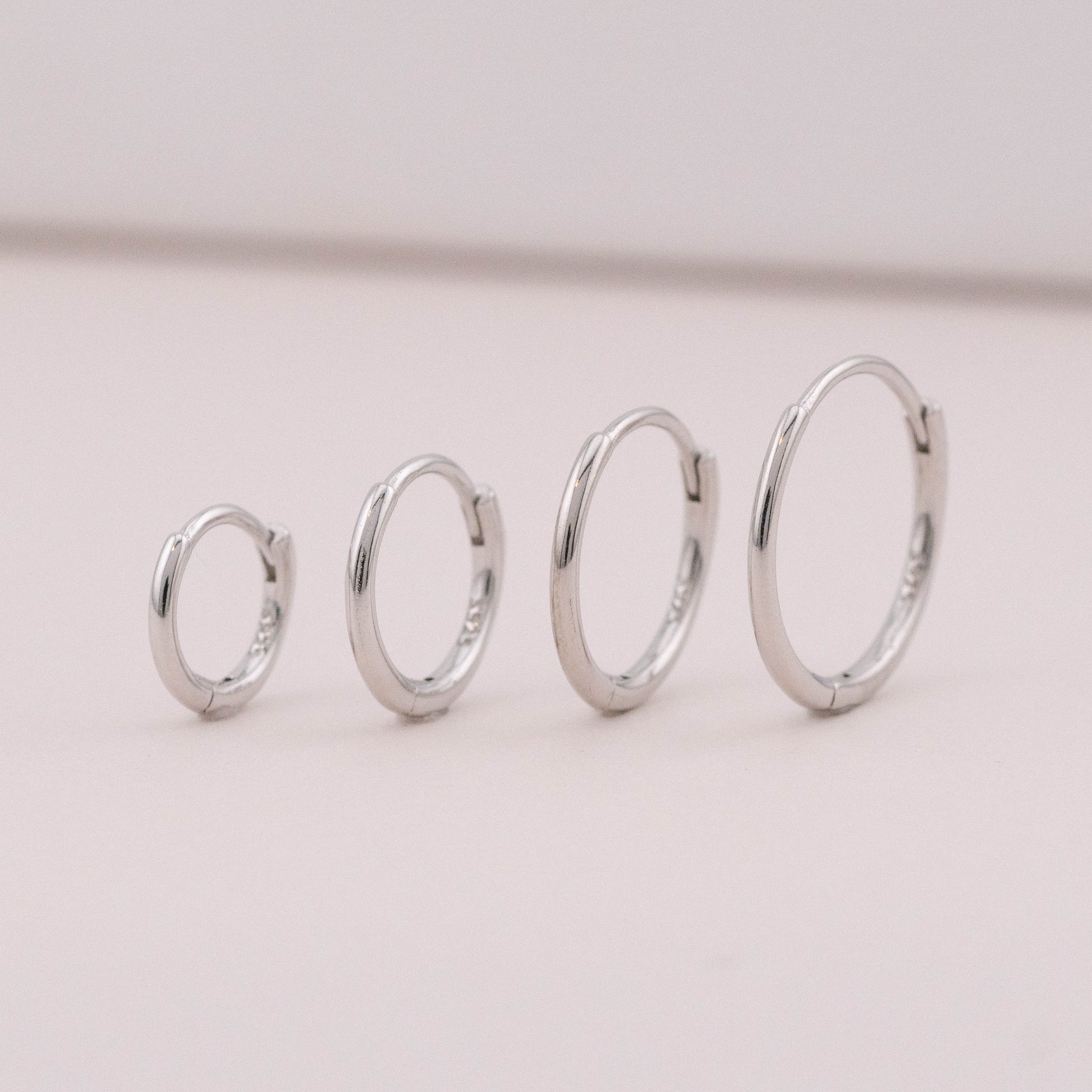 mini hoop earrings in different sizes are standing upright, showing it could be worn as stack sets