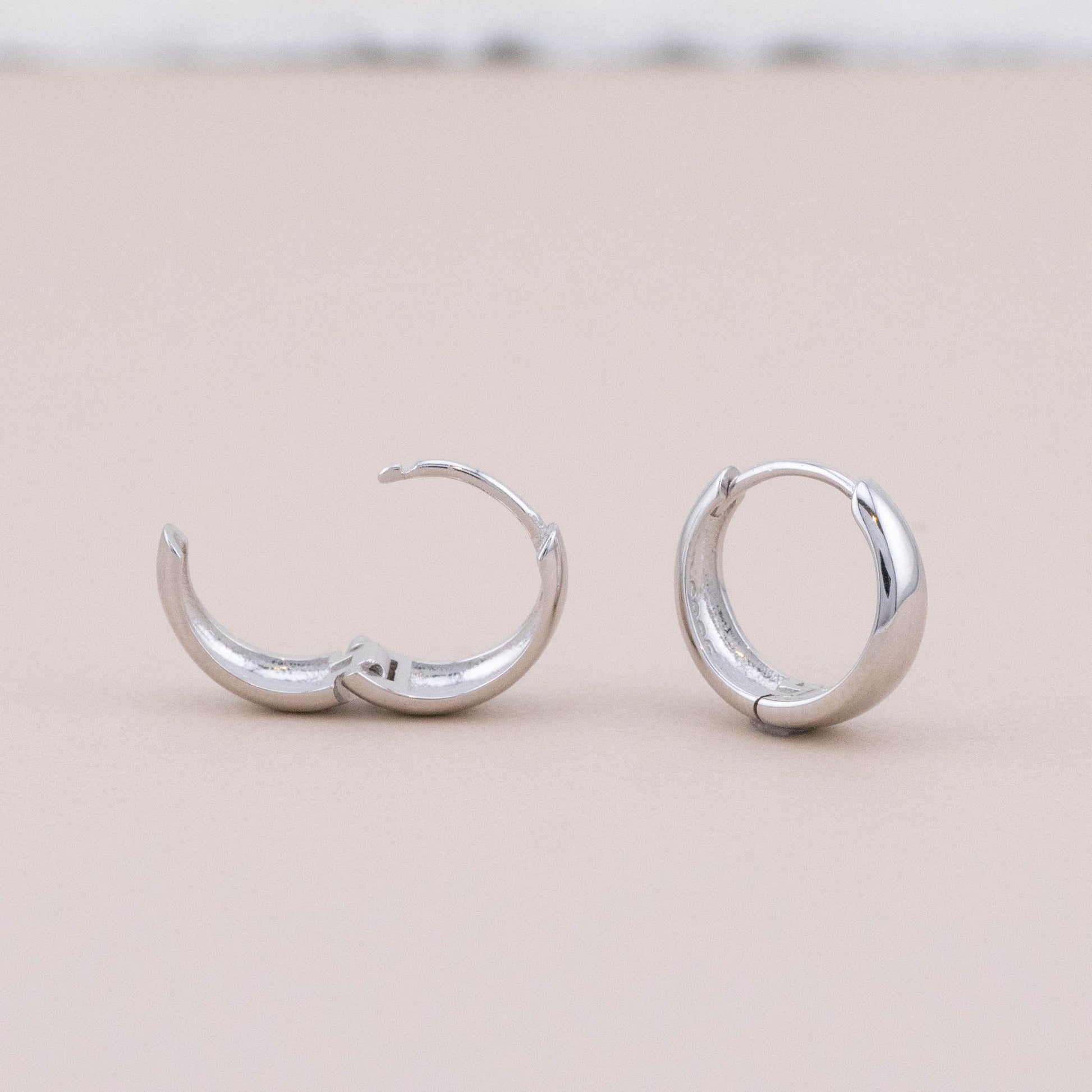 Mini thick hoop earrings: one closed, one open, hinge visible. Waterproof, tarnish-free, stylish.