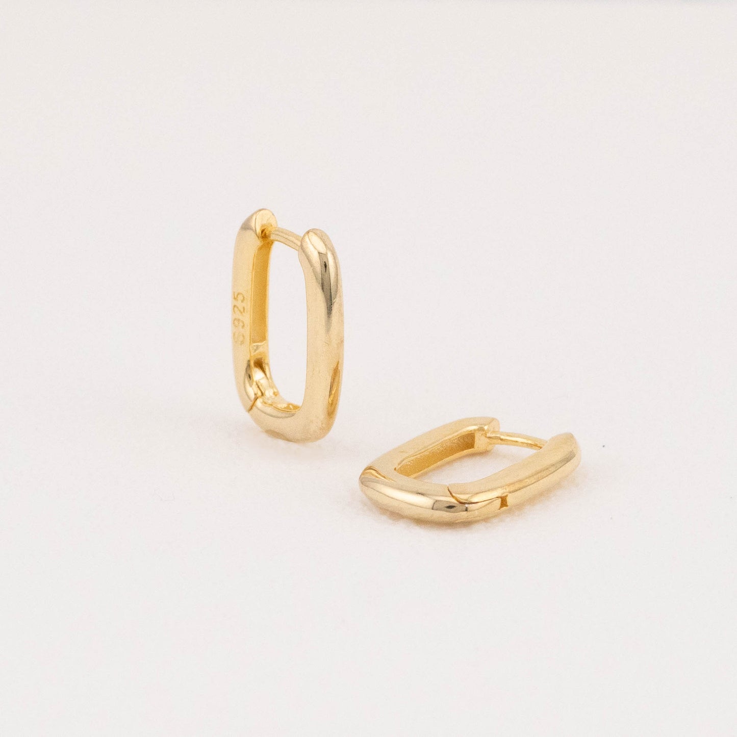 Mini rectangular 14K gold vermeil hoop earrings: one angled, one flat on white surface.